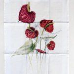 A tea towel printed in full colour with a botanical painting of red anthurium flowers.